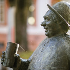 Das Bild zeigt die Skulptur eines trinkenden Mannes