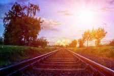 Das Bild zeigt Bahngleise im Sonnenschein