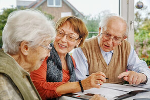 Drei Senior:innen sitzen zusammen an einem Tisch © AdobeStock Ingo Bartussek
