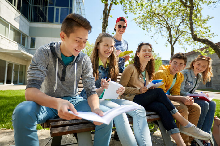 Foto Schülerin und Schüler im Klassenraum lachen in Kamera