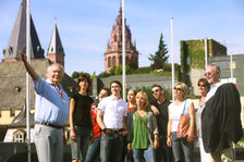 Ein Stadtführer mit einer Touristengruppe; im Hintergrund der Dom